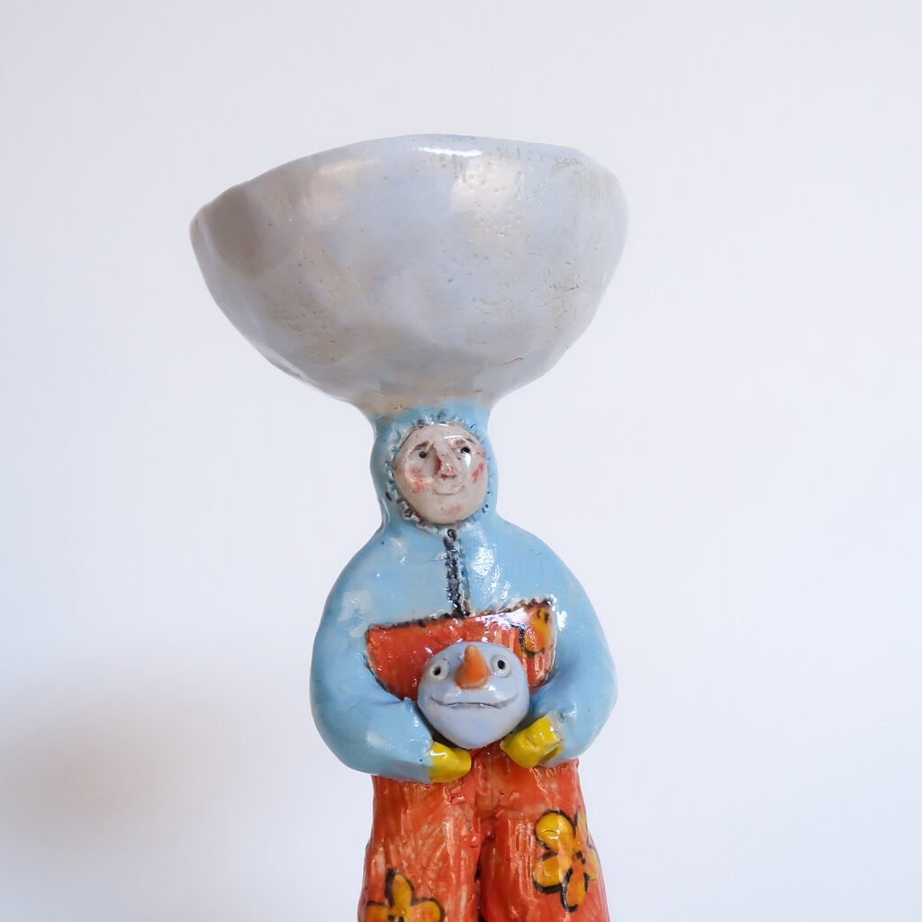 ceramic candlestick with a sculpture of a wintery child