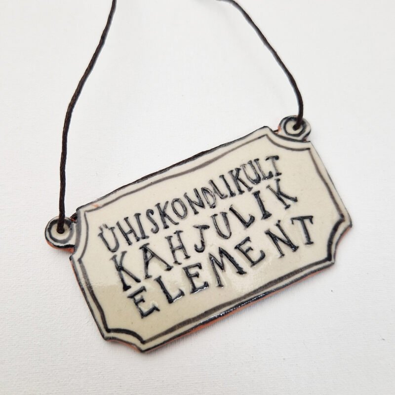 rectangular ceramic pendant with the words ühiskondlikult kahjulik element