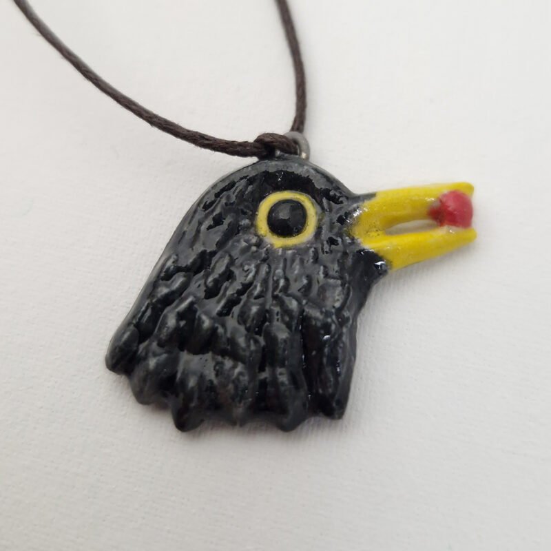 ceramic pendant depicting a blackbird with a red berry in its beak