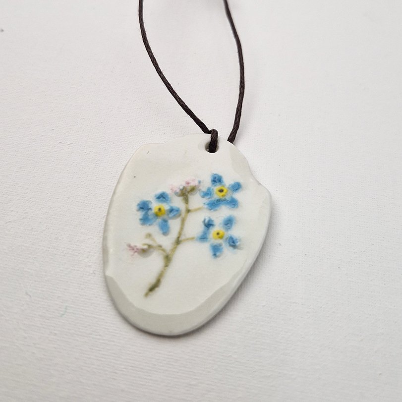 porcelain pendant depicting a forget-me-not