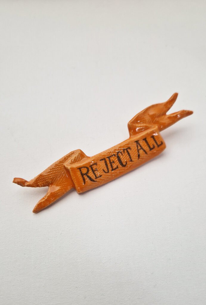 ceramic brooch with the words reject all