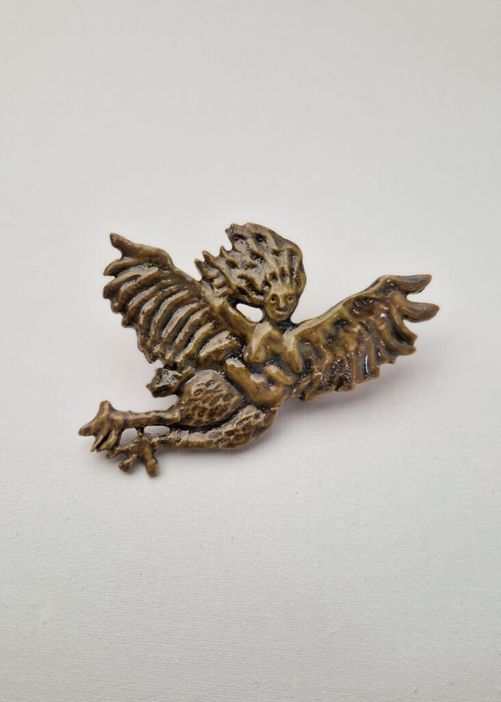 ceramic brooch depicting a harpy