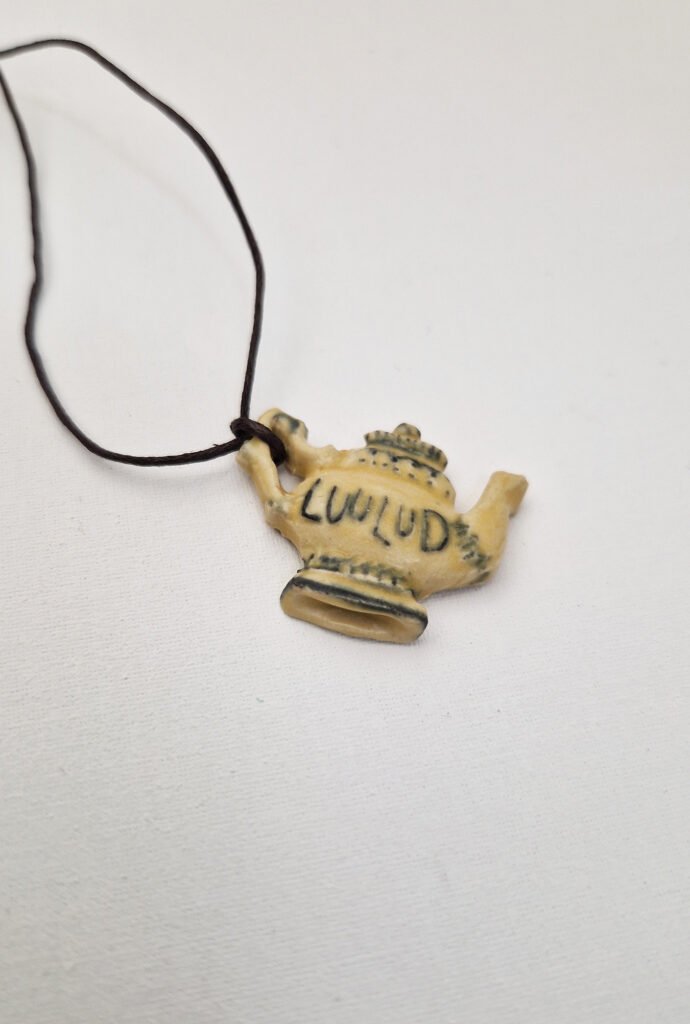 photo of a ceramic pendant the shape of a teapot