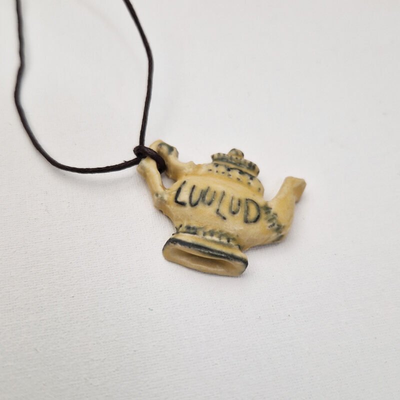 photo of a ceramic pendant the shape of a teapot