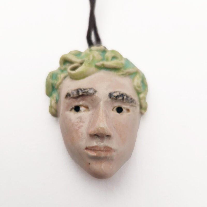 ceramic pendant of a sculpted head of a boy