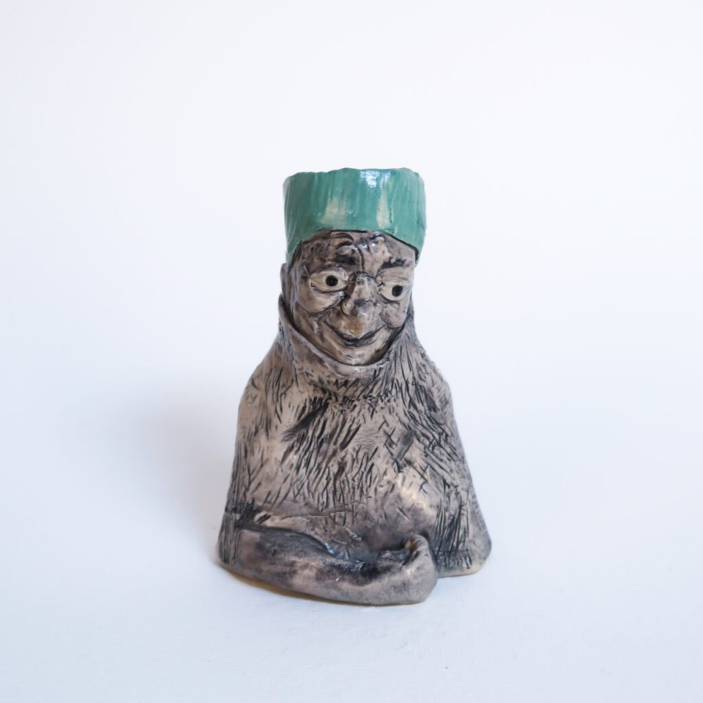 small ceramic candlestick in the shape of an older woman