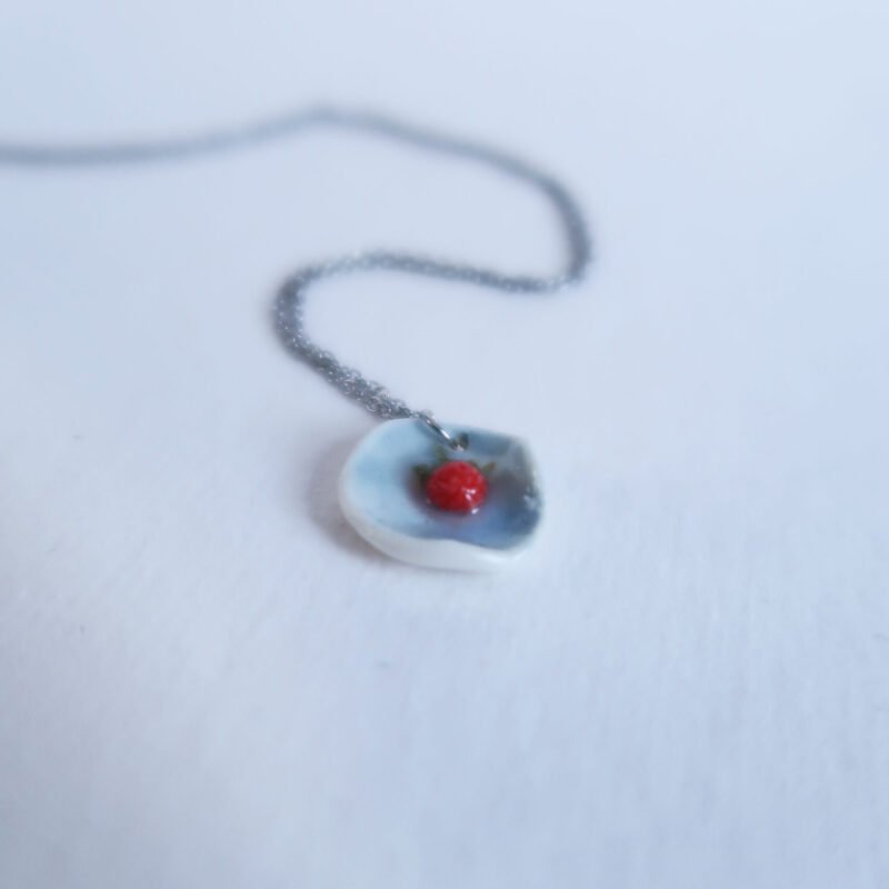 photo of a porcelain pendant with a tiny wild strawberry
