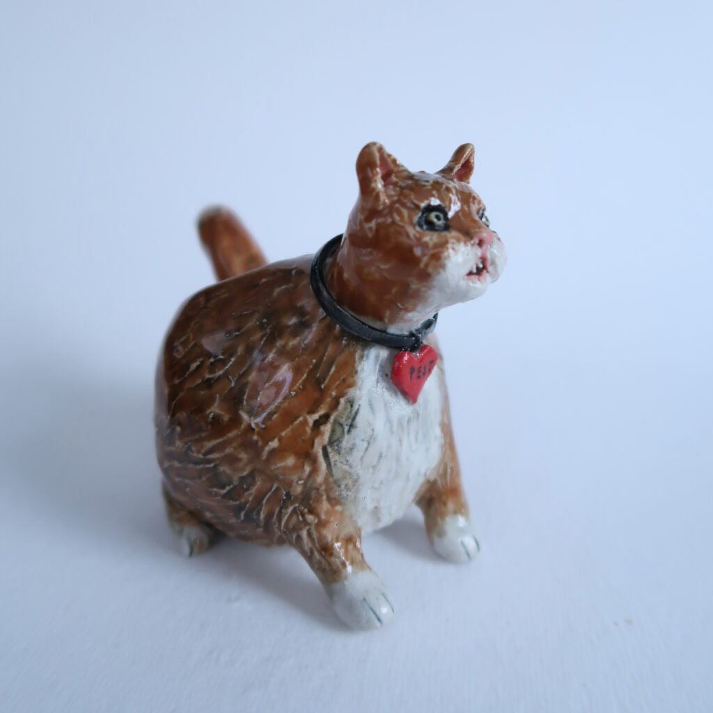photo of a ceramic salt pig in the shape of a fat rred pinhead cat