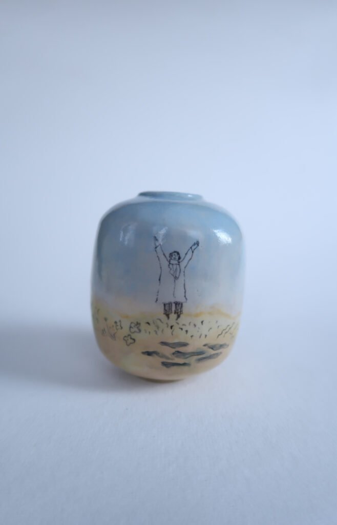small bulbous ceramic vase with an underglaze painting of three figures
