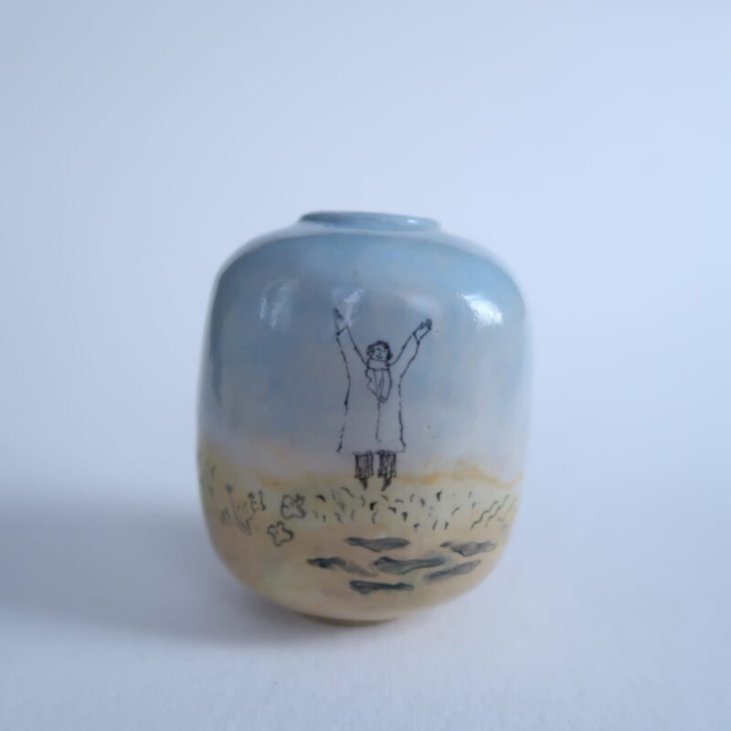 small bulbous ceramic vase with an underglaze painting of three figures