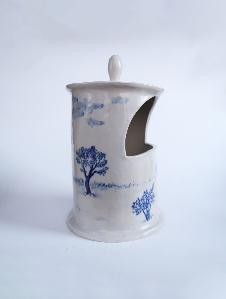 photo of a traditional white salt cellar covered in a blue underglaze painting of an apple orchard