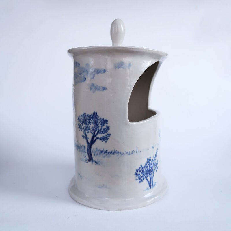 photo of a traditional white salt cellar covered in a blue underglaze painting of an apple orchard
